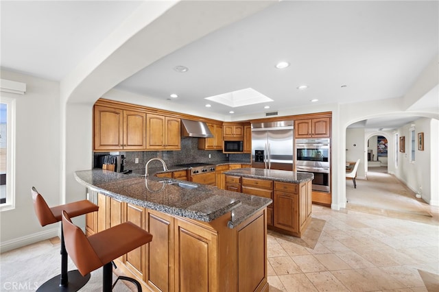 911 Buena Vis Unit 1, San Clemente, CA 92672 - kitchen with appliances with stainless steel finishes, a sink, arched walkways, ventilation hood, and backsplash