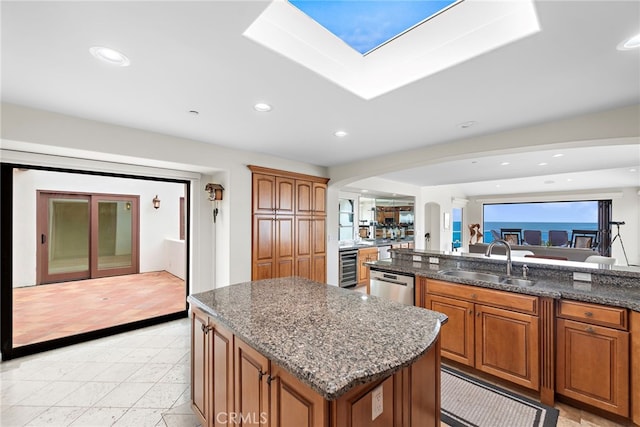 911 Buena Vis Unit 1, San Clemente, CA 92672 - kitchen featuring a sink, arched walkways, a kitchen island, dishwasher, and brown cabinets