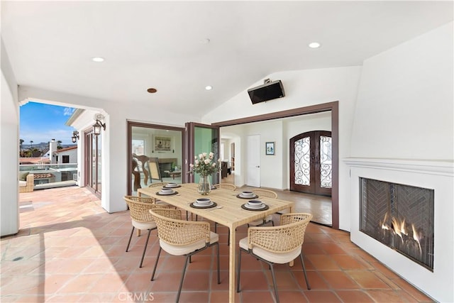911 Buena Vis Unit 1, San Clemente, CA 92672 - dining area with french doors, vaulted ceiling, recessed lighting, tile patterned floors, and a lit fireplace