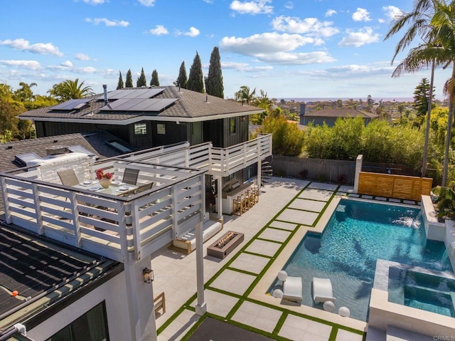 1368 Hymettus Ave, Encinitas, CA 92024 - back of house featuring roof mounted solar panels, a pool with connected hot tub, a patio area, a fenced backyard, and a balcony