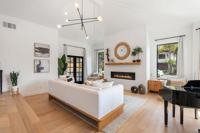 1368 Hymettus Ave, Encinitas, CA 92024 - living area with light wood-style flooring, a chandelier, lofted ceiling, and a glass covered fireplace