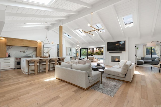 1368 Hymettus Ave, Encinitas, CA 92024 - living area with a chandelier, beamed ceiling, light wood-type flooring, a fireplace, and a skylight