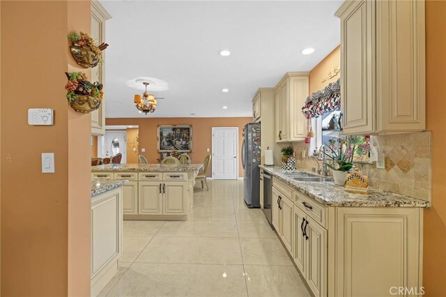 16900 Mayall St, North Hills, CA 91343 - kitchen with cream cabinetry, a sink, stainless steel appliances, a peninsula, and tasteful backsplash