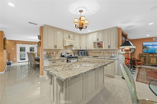 16900 Mayall St, North Hills, CA 91343 - kitchen featuring stainless steel range oven, cream cabinets, custom exhaust hood, backsplash, and recessed lighting