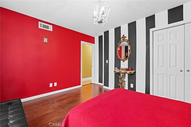 16900 Mayall St, North Hills, CA 91343 - bedroom featuring wood finished floors, a chandelier, baseboards, an accent wall, and a closet