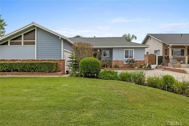 16900 Mayall St, North Hills, CA 91343 - view of front of property with brick siding, a garage, and a front yard