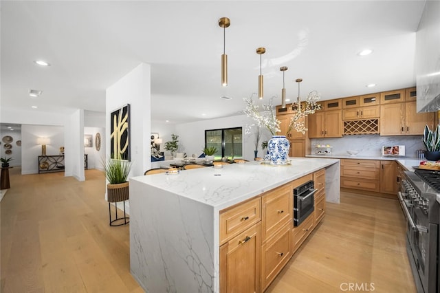 3209 Lakeknoll Dr, Fullerton, CA 92835 - kitchen featuring range with two ovens, light wood-style flooring, light stone counters, a kitchen island, and recessed lighting