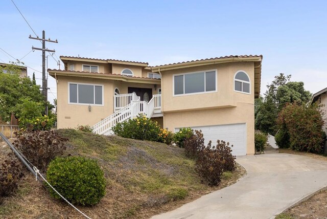 1295 Buenos Ave, San Diego, CA 92110 - view of front of property with an attached garage, stucco siding, concrete driveway, a tiled roof, and stairs
