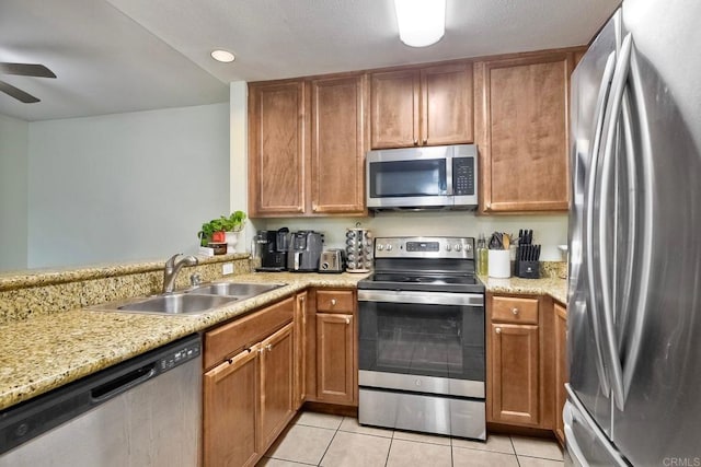 145 W El Norte Pkwy Unit 123, Escondido, CA 92026 - kitchen featuring appliances with stainless steel finishes, a sink, a ceiling fan, light tile patterned floors, and light stone counters