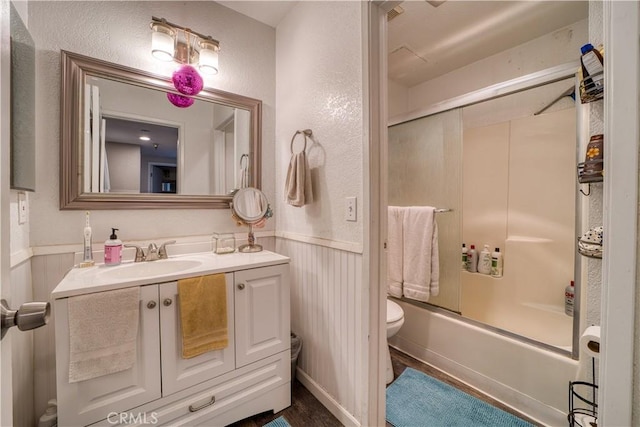 45 Stenner St Unit E, San Luis Obispo, CA 93405 - bathroom with toilet, vanity, a wainscoted wall, combined bath / shower with glass door, and a textured wall