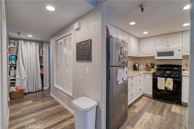 45 Stenner St Unit E, San Luis Obispo, CA 93405 - kitchen with white microwave, gas stove, freestanding refrigerator, wood finished floors, and recessed lighting