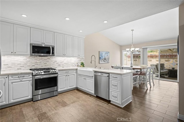 23291 Via Gaudix, Mission Viejo, CA 92691 - kitchen featuring appliances with stainless steel finishes, lofted ceiling, a peninsula, a sink, and a chandelier