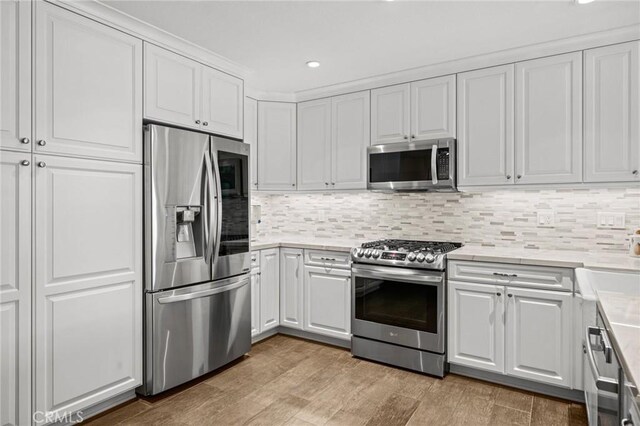 23291 Via Gaudix, Mission Viejo, CA 92691 - kitchen with stainless steel appliances, white cabinets, light countertops, backsplash, and recessed lighting