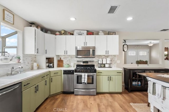 11029 Bel Air Ave, Ontario, CA 91762 - kitchen with appliances with stainless steel finishes, green cabinets, decorative backsplash, and recessed lighting