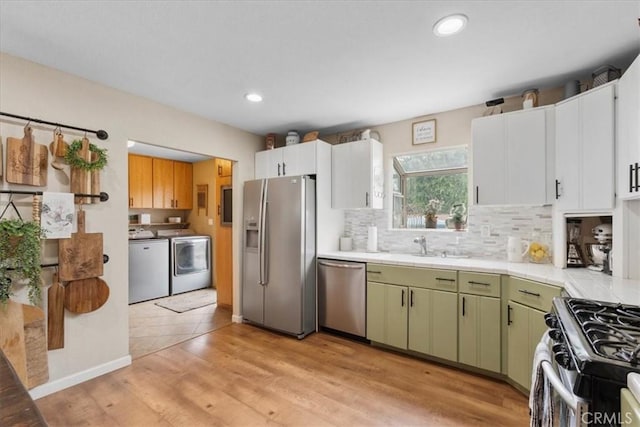 11029 Bel Air Ave, Ontario, CA 91762 - kitchen featuring appliances with stainless steel finishes, washer and dryer, tile countertops, green cabinets, and decorative backsplash