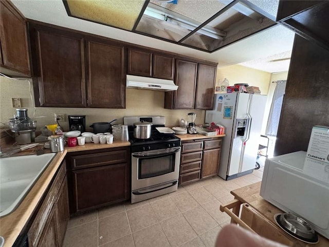 610 S Santa Fe St Unit 2, Hemet, CA 92543 - kitchen with stainless steel gas stove, under cabinet range hood, white fridge with ice dispenser, light countertops, and dark brown cabinets
