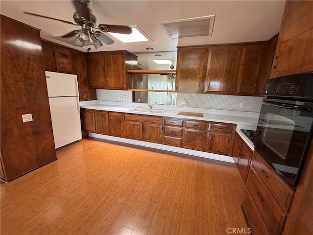 13800M1-39K Annandale Dr, Seal Beach, CA 90720 - kitchen with freestanding refrigerator, black oven, open shelves, a sink, and brown cabinetry