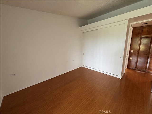 13800M1-39K Annandale Dr, Seal Beach, CA 90720 - unfurnished bedroom with dark wood-style flooring, a closet, and baseboards