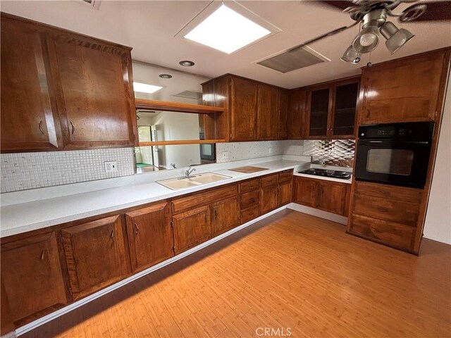 13800M1-39K Annandale Dr, Seal Beach, CA 90720 - kitchen with oven, cooktop, a sink, tasteful backsplash, and light wood finished floors