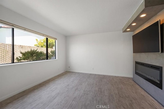 676 N 12th St Unit 3, Grover Beach, CA 93433 - unfurnished living room with wood finished floors, recessed lighting, baseboards, and a glass covered fireplace