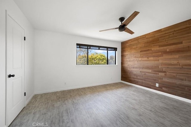676 N 12th St Unit 3, Grover Beach, CA 93433 - unfurnished room with wood walls, a ceiling fan, wood finished floors, and baseboards