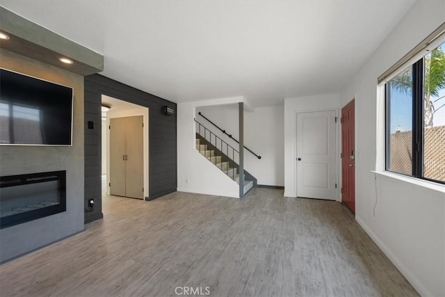 676 N 12th St Unit 3, Grover Beach, CA 93433 - unfurnished living room featuring wood finished floors, baseboards, stairs, recessed lighting, and a glass covered fireplace