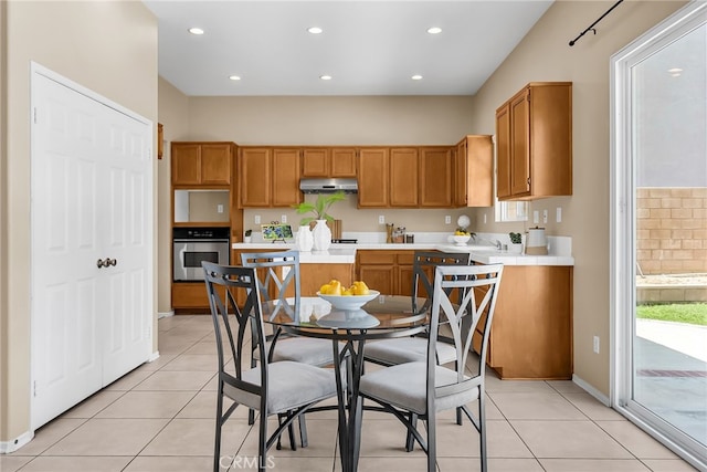 11868 Amethyst Ct, Jurupa Valley, CA 91752 - kitchen with stainless steel oven, under cabinet range hood, light tile patterned flooring, recessed lighting, and baseboards