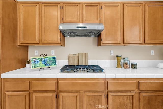 11868 Amethyst Ct, Jurupa Valley, CA 91752 - kitchen with under cabinet range hood, stainless steel gas stovetop, and light countertops