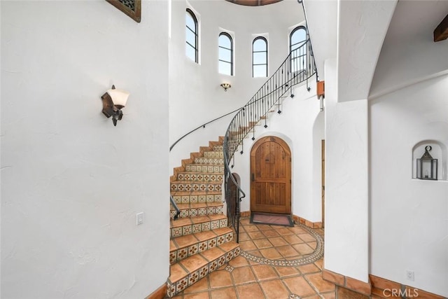 4950 Davenport Creek Rd, San Luis Obispo, CA 93401 - foyer featuring arched walkways, a high ceiling, stairway, and inlaid floor details