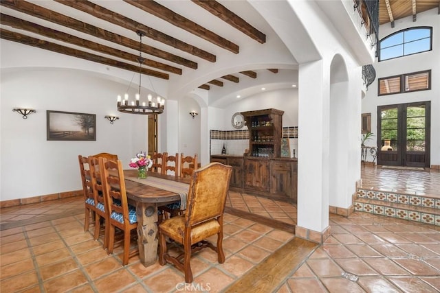 4950 Davenport Creek Rd, San Luis Obispo, CA 93401 - dining area featuring a chandelier, arched walkways, french doors, beam ceiling, and tile patterned flooring