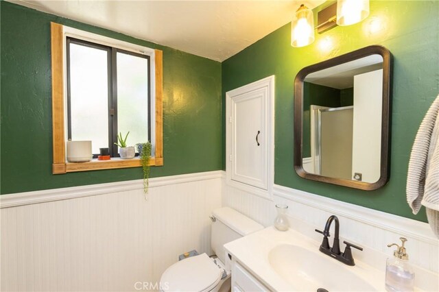 33310 Conway Dr, Running Springs, CA 92308 - bathroom featuring wainscoting, toilet, vanity, and an enclosed shower