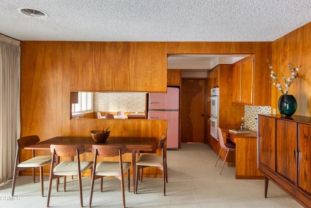 85 Gardenia Ct, Upland, CA 91786 - dining room with a textured ceiling, wood walls, and light floors