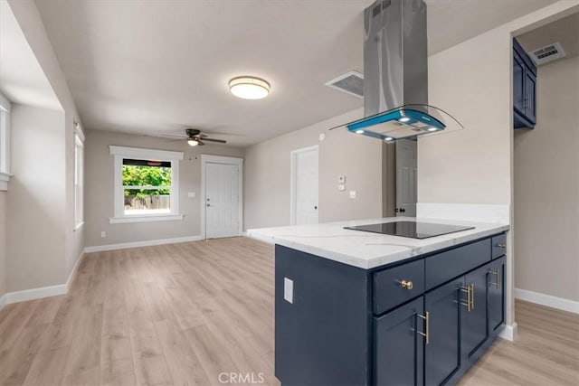 1906 N Fruit Ave, Fresno, CA 93705 - kitchen featuring island exhaust hood, black electric cooktop, light wood finished floors, and blue cabinetry