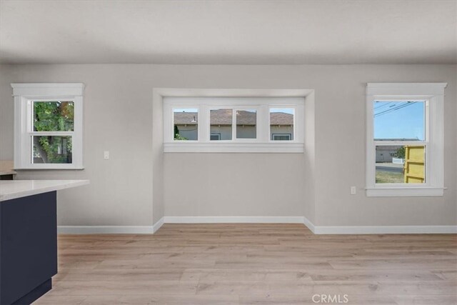 1906 N Fruit Ave, Fresno, CA 93705 - unfurnished dining area with light wood-style floors and baseboards