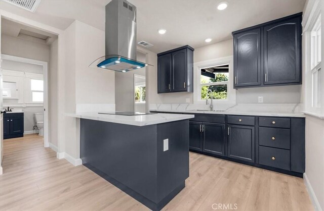 1906 N Fruit Ave, Fresno, CA 93705 - kitchen with island exhaust hood, a sink, light wood-type flooring, a peninsula, and recessed lighting