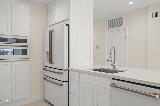 1194 Kingston Ln, Ventura, CA 93001 - kitchen with white appliances, a sink, light stone counters, white cabinetry, and recessed lighting