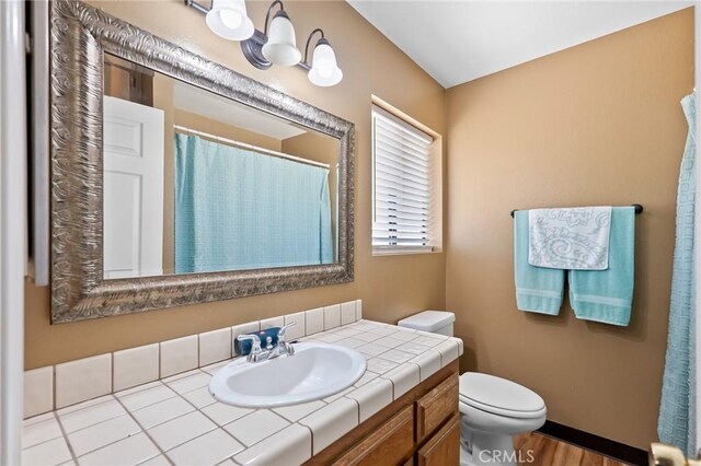 8600 San Vicente Dr, Yucca Valley, CA 92284 - bathroom with toilet, vanity, wood finished floors, curtained shower, and baseboards