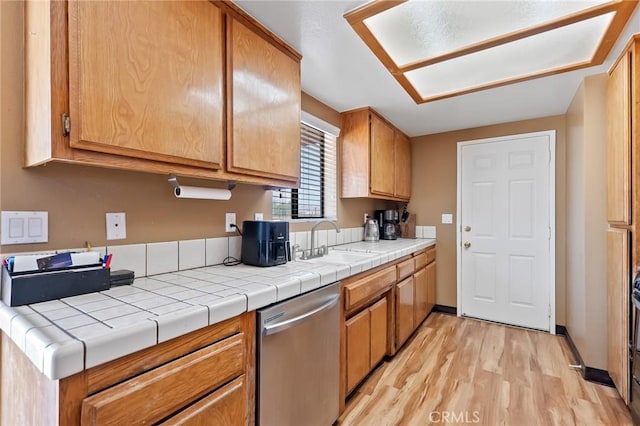8600 San Vicente Dr, Yucca Valley, CA 92284 - kitchen with dishwasher, light wood finished floors, a sink, and brown cabinetry