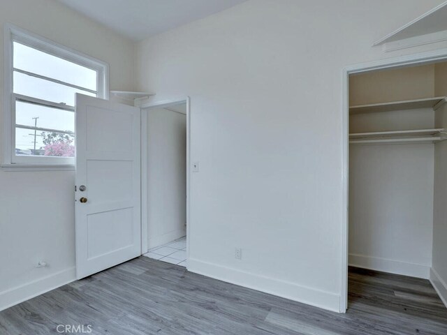 4265 Crescent Ave, Cypress, CA 90630 - unfurnished bedroom featuring a closet, wood finished floors, and baseboards