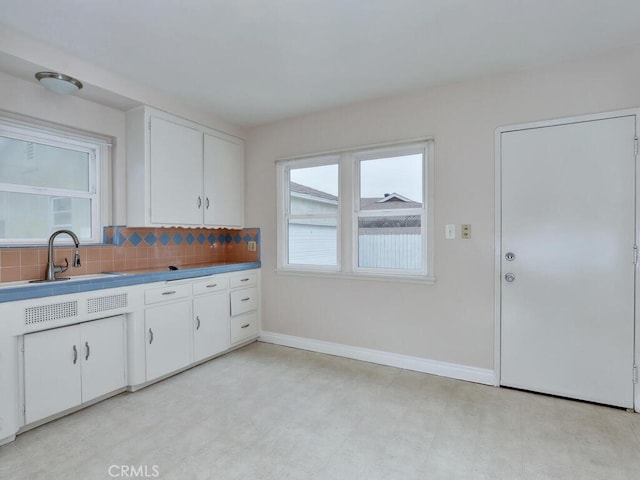 4265 Crescent Ave, Cypress, CA 90630 - kitchen with light flooring, baseboards, white cabinetry, and tasteful backsplash