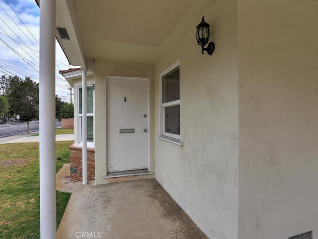 4265 Crescent Ave, Cypress, CA 90630 - doorway to property featuring stucco siding, a porch, and a yard