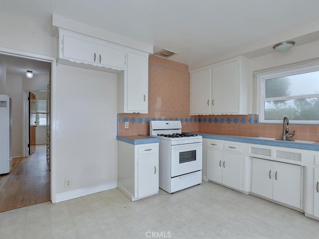 4265 Crescent Ave, Cypress, CA 90630 - kitchen with white gas stove, a sink, light floors, and tasteful backsplash