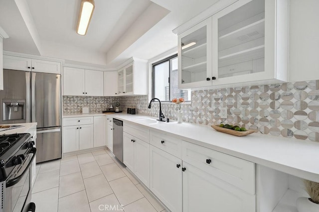 6101 Fulton Ave Unit 8, Van Nuys, CA 91401 - kitchen featuring appliances with stainless steel finishes, light countertops, white cabinetry, tasteful backsplash, and glass insert cabinets