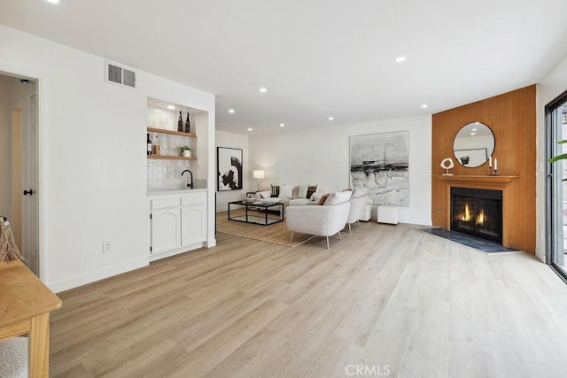 6101 Fulton Ave Unit 8, Van Nuys, CA 91401 - living room featuring wet bar, light wood finished floors, recessed lighting, a fireplace with flush hearth, and baseboards