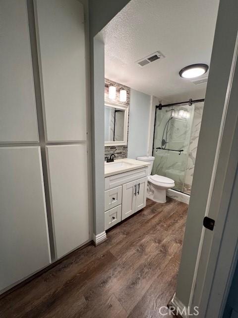 2015 Lakeridge Cir Unit 301, Chula Vista, CA 91913 - full bath with a marble finish shower, wood finished floors, vanity, toilet, and a textured ceiling