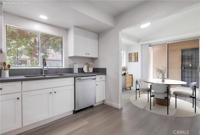 18417 Santar St, Rowland Heights, CA 91748 - kitchen featuring stainless steel dishwasher, a sink, light wood-type flooring, dark countertops, and white cabinets