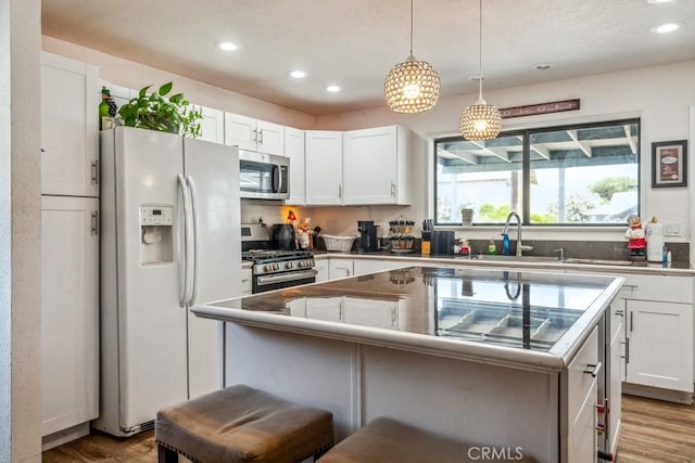 33206 Churchill St, Lake Elsinore, CA 92530 - kitchen with stainless steel appliances, recessed lighting, white cabinets, a kitchen island, and a breakfast bar