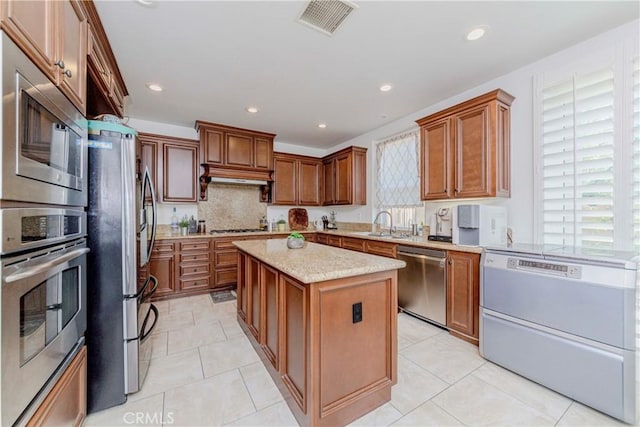 1330 W Marigold Ave, La Habra, CA 90631 - kitchen with appliances with stainless steel finishes, a kitchen island, decorative backsplash, brown cabinets, and recessed lighting