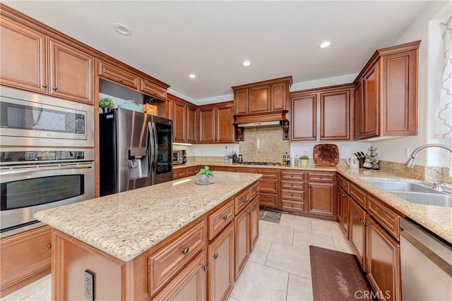 1330 W Marigold Ave, La Habra, CA 90631 - kitchen with stainless steel appliances, a sink, light stone counters, decorative backsplash, and a center island