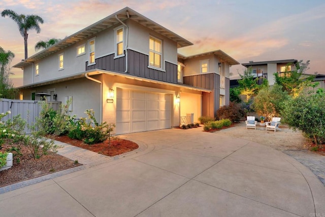 939 Moonstone Ct, Encinitas, CA 92024 - modern home featuring an attached garage, driveway, stucco siding, and board and batten siding